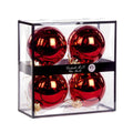 Four shiny gold glass Christmas ornaments 10 cm diameter, inside a clear rectangular display box with a black frame and a black band label reading 'Goodwill M&G Co. Glass Baubles'. Photographed on a white backgraund 