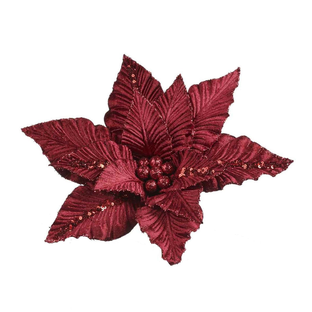 A single artificial poinsettia-style holiday flower in deep burgundy red, with textured leaves and small glittery accents, isolated on a plain white background.