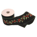 A roll of black velvet ribbon with an embroidered holly and berry pattern, shown partially unrolled on a white background.