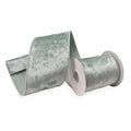 A roll of textured, crushed velvet ribbon in a muted sage green color, shown partially unrolled on a clean white background.